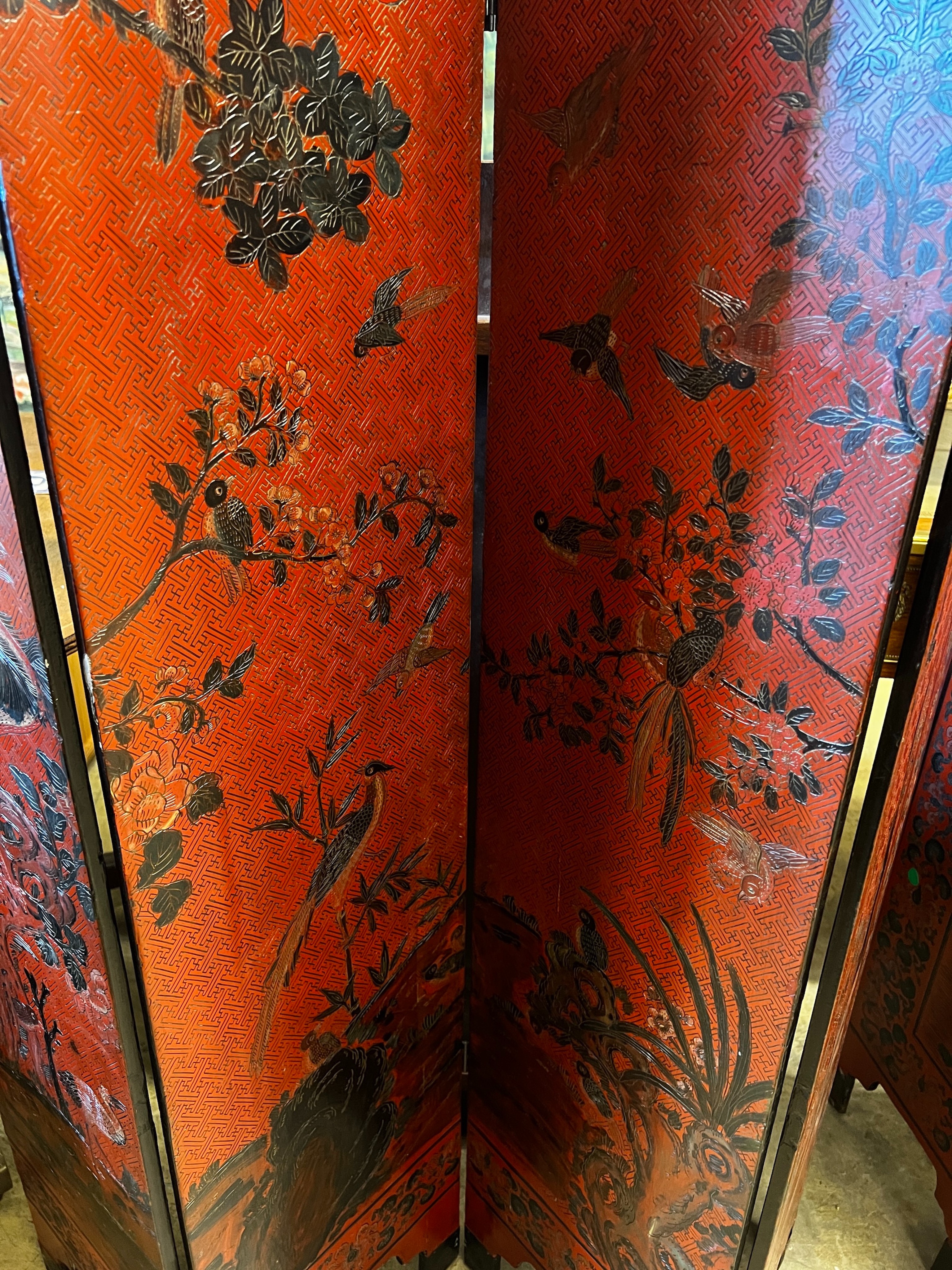 A pair of Chinese four fold lacquer screens decorated with exotic birds amongst branches, each panel width 30cm, height 141cm